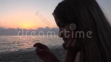 海滩上的孩子，日落时在海滩上玩耍的孩子，看着女孩在学习卵石
